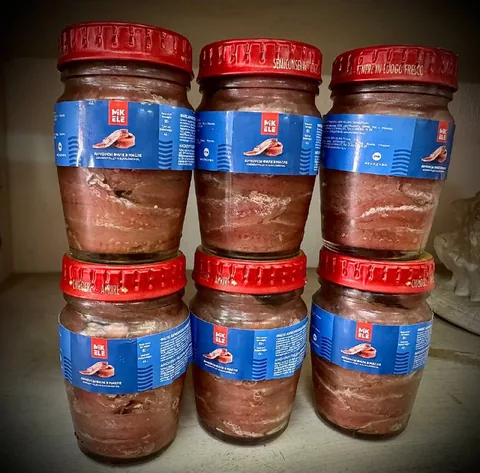 Банки анчоусов с красными крышками